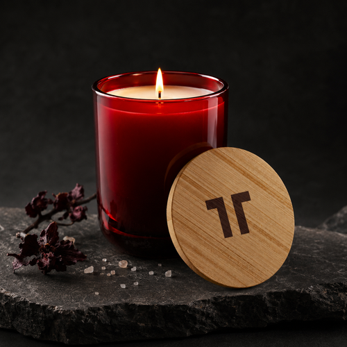 Bloodwood 390g candle in Cranberry Glow glass on dark stone