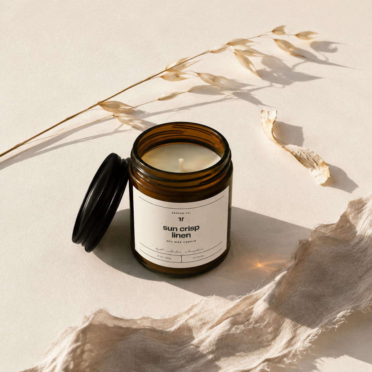 Open TenTen Sun Crisp Linen 255g candle with flax linen and dried oat stems
